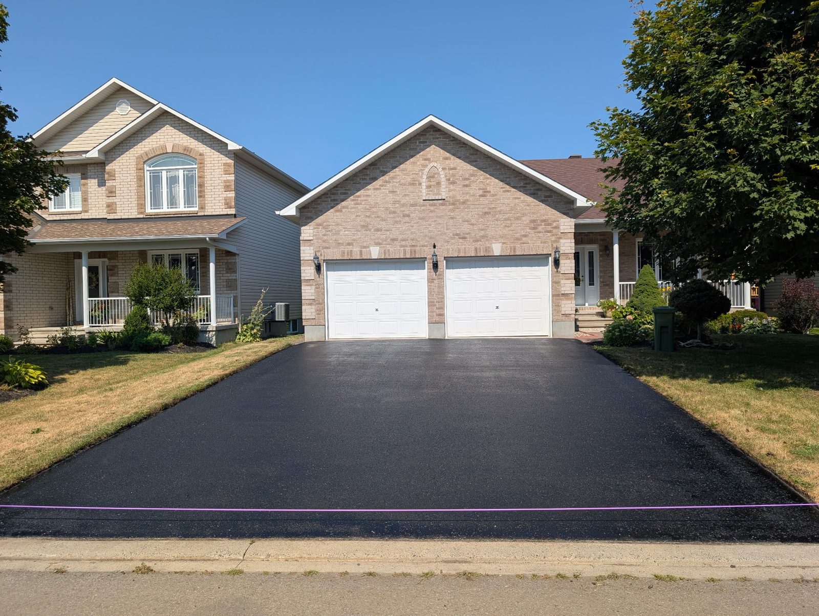 Driveway after sealcoating with taped edge