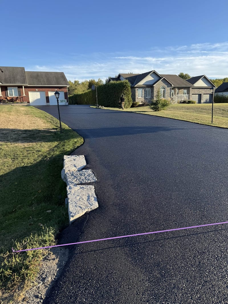 Long rural driveway after professional sealing