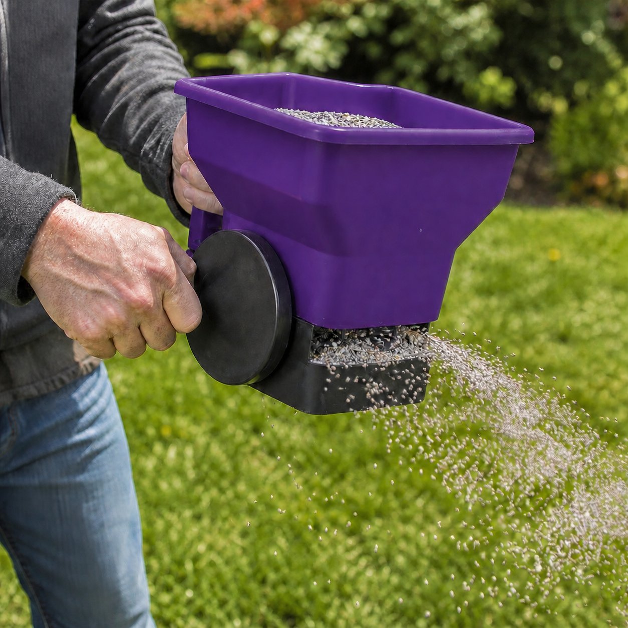 Fertilizer spreader applying nutrients across green grass